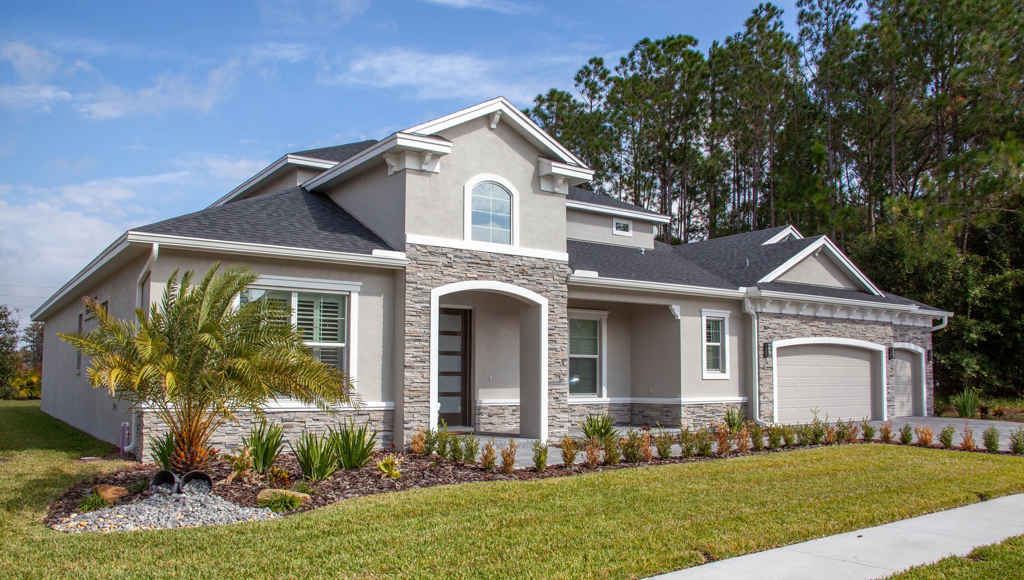 One-story Florida home with a palm tree and a green lawn